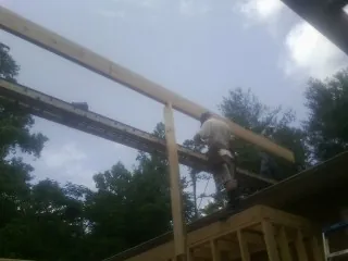 Carpenter setting a ridge beam over a new addition frame — Ice Dam Removal by Roofing Brothers in Rosemead