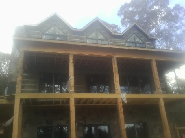 Dormers and porch framing on a large log home under construction — Roof Coating work by our crew in Rosemead